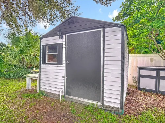 a view of a house with a yard and large trees