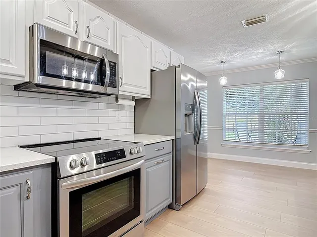 a kitchen with stainless steel appliances a stove a microwave oven cabinets and a sink