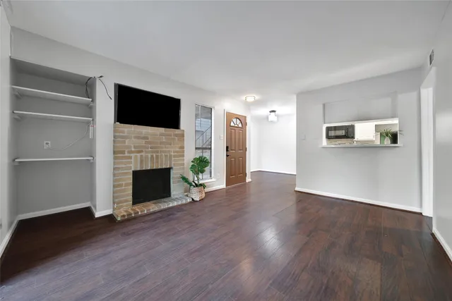 a view of a livingroom with a fireplace wooden floor a fireplace and window