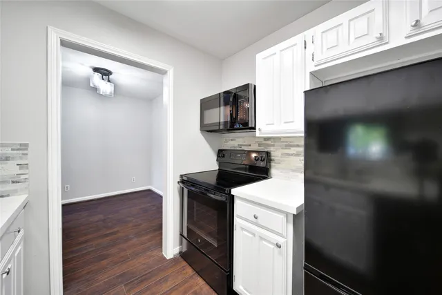 a kitchen with a refrigerator sink and cabinets