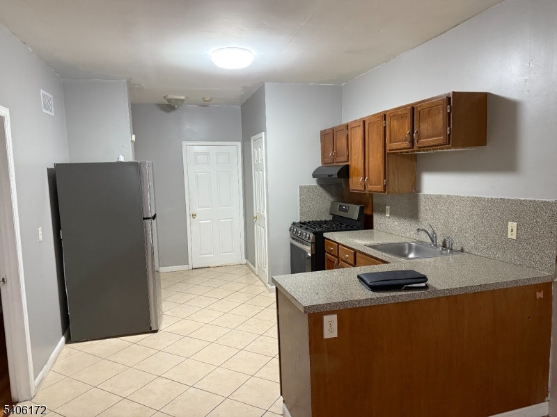 77 Garfield Avenue, Unit 2 Paterson, NJ 07522 - Photo 4 of 8 a kitchen with a refrigerator and a stove