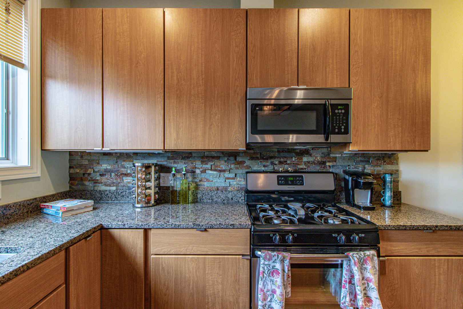 48 Northfield Terrace Wheeling, IL 60090 - Photo 14 of 36 a kitchen with granite countertop a stove top oven microwave and cabinets