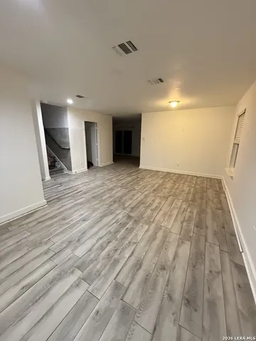 a view of empty room with wooden floor