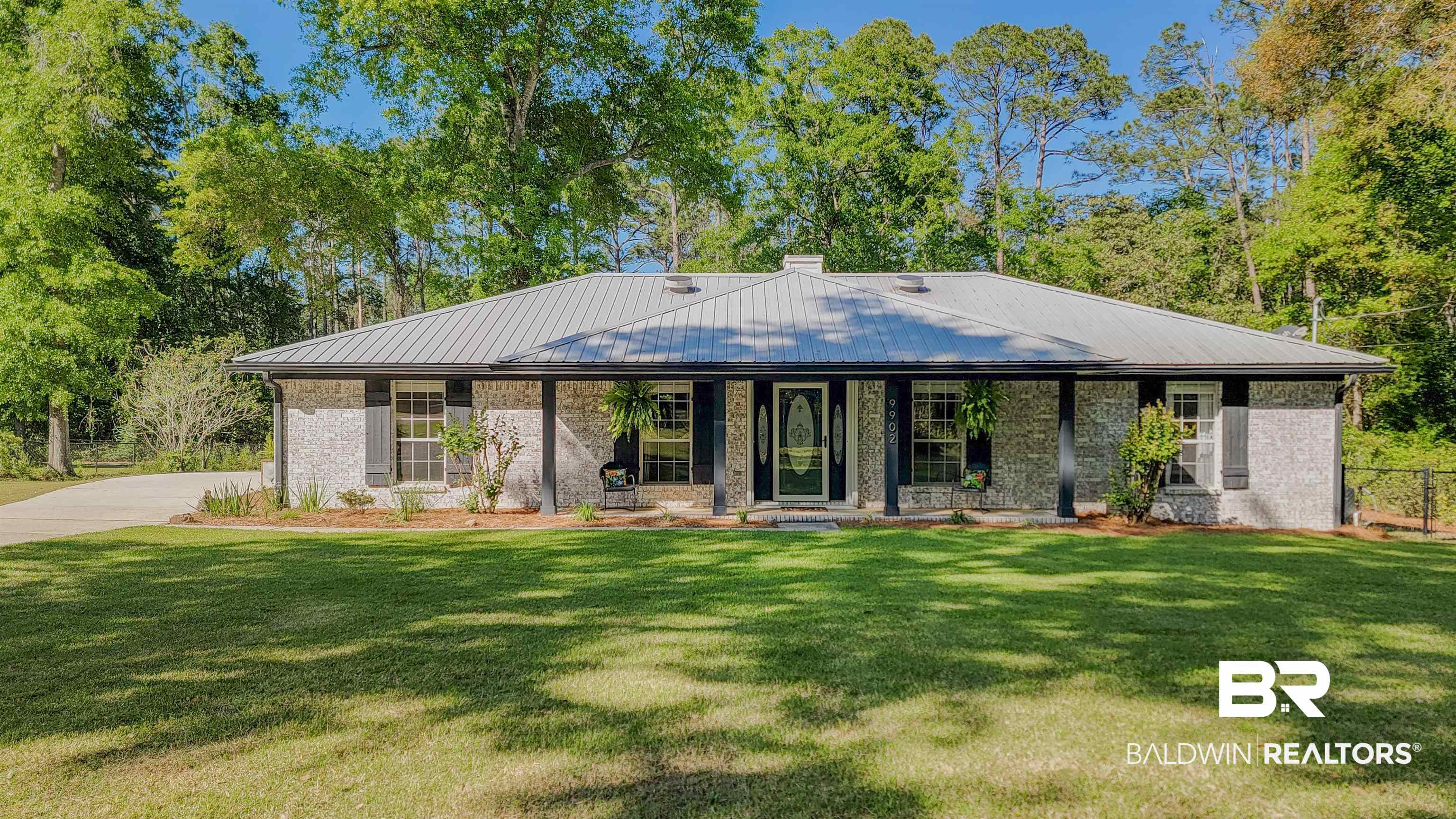 9902 Clarke Ridge Road Foley, AL 36535 - Photo 2 of 61 Back of property featuring metal roof, a lawn, covered porch, and fence