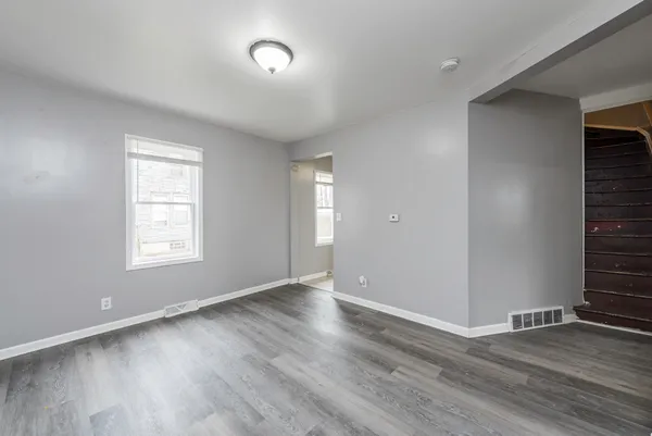 an empty room with wooden floor and window