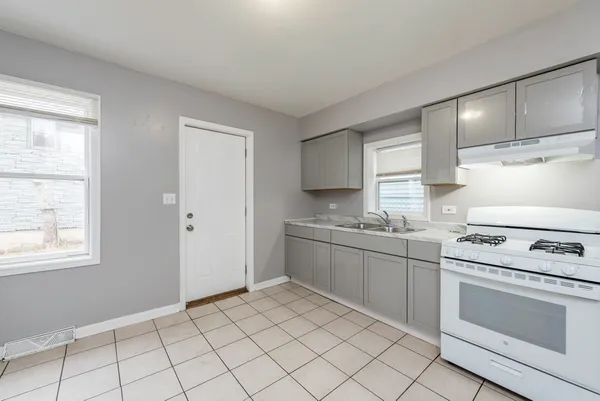 a kitchen with granite countertop white cabinets a sink and white appliances