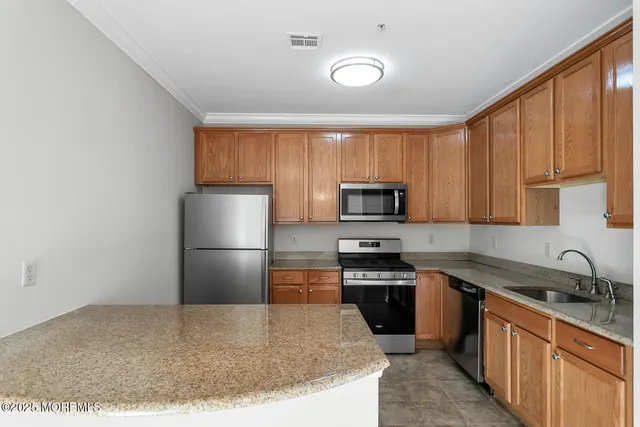 a kitchen with stainless steel appliances granite countertop a refrigerator a stove a sink a microwave and cabinets