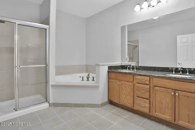 a spacious bathroom with a shower sink and mirror