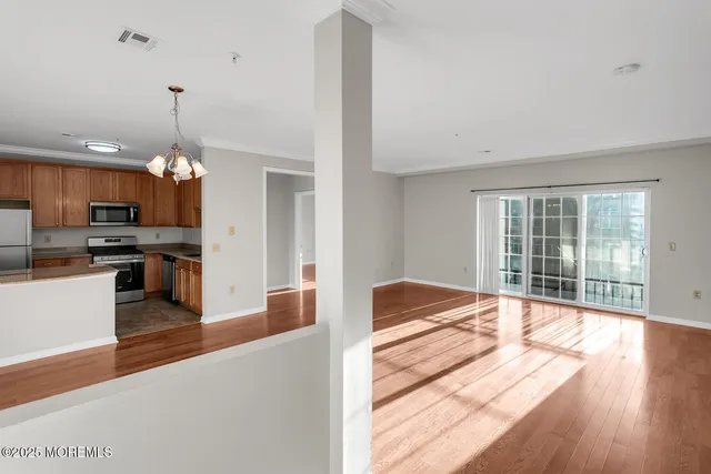 a open kitchen with granite countertop a stove top oven a sink dishwasher a dining table and chairs with wooden floor