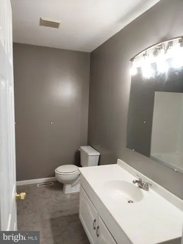 a bathroom with a granite countertop toilet and sink