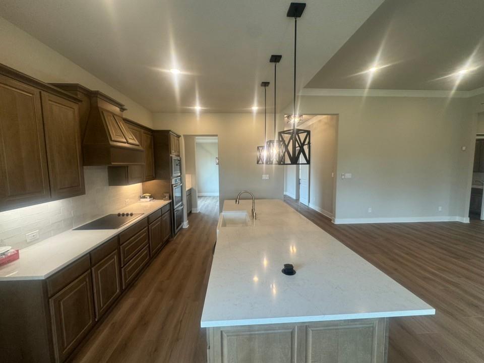 412 Indian Crk Road Van Alstyne, TX 75495 - Photo 10 of 24 a kitchen with stainless steel appliances a large counter top a stove top oven and wooden floor