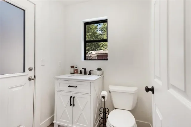 a bathroom with a toilet a sink and a window