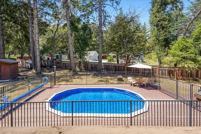a view of house with swimming pool and seating space