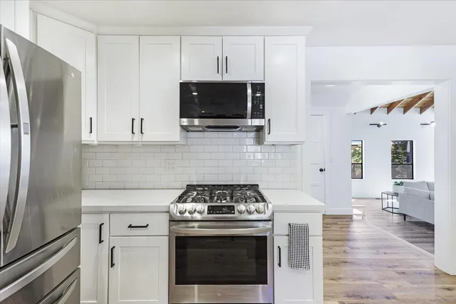 a kitchen with stainless steel appliances a stove a microwave and cabinets