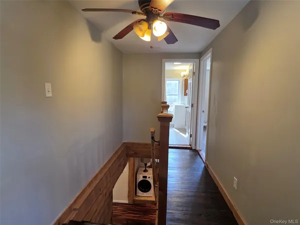 a view of a hallway with wooden floor and staircase