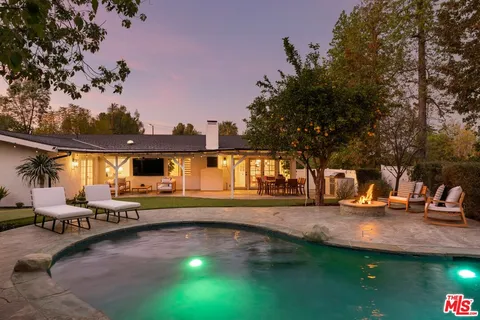 a view of a house with swimming pool and sitting area