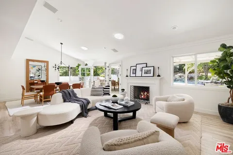 a living room with furniture a fireplace and a large window