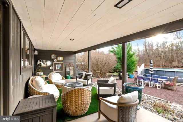 a living room with furniture a rug potted plant and a large window