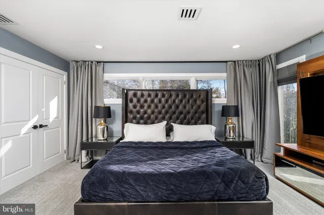 a bedroom with a large bed and a flat tv screen