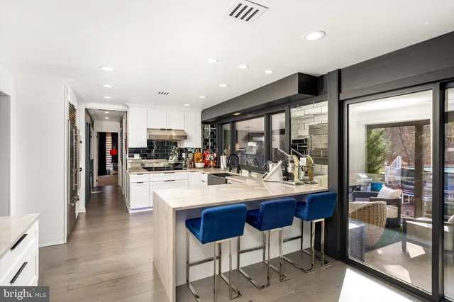 a kitchen with stainless steel appliances kitchen island granite countertop a refrigerator and a dining table