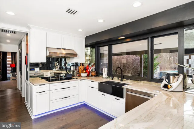 a kitchen with stainless steel appliances kitchen island granite countertop a stove and a sink