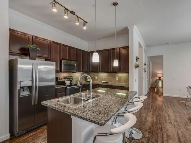 a kitchen with stainless steel appliances granite countertop a sink refrigerator and cabinets
