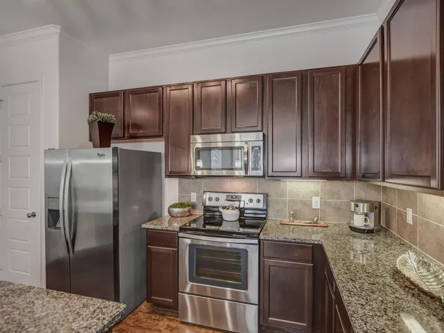 a kitchen with a refrigerator sink and cabinets