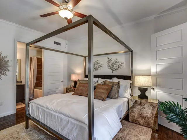a bedroom with a large bed and a chandelier