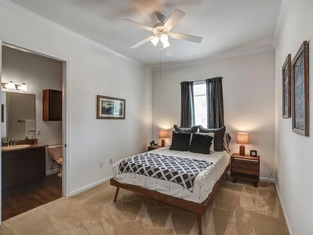 a bedroom with a large bed and a chandelier