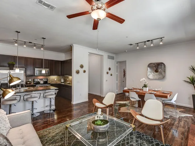 a living room with furniture kitchen view and a chandelier