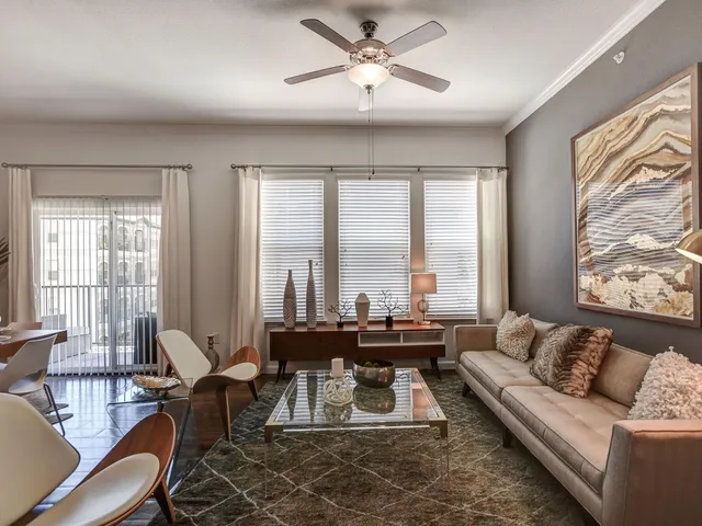 a living room with furniture and large windows