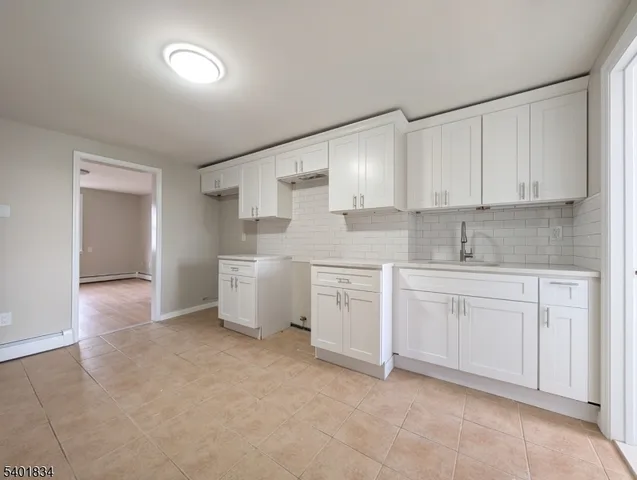 a kitchen with granite countertop white cabinets white stainless steel appliances with a sink and dishwasher