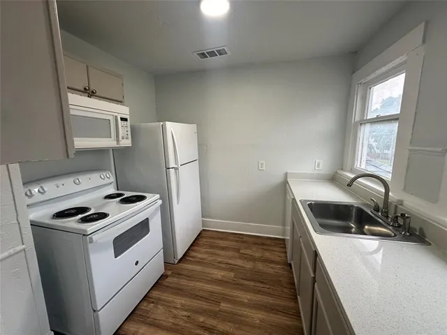 a kitchen with a stove sink and a refrigerator