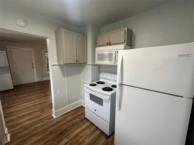 a white refrigerator freezer and a stove sitting inside of a kitchen