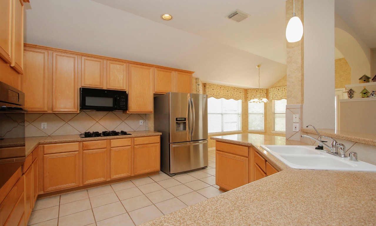 1114 Bringewood Chase Drive Spring, TX 77379 - Photo 16 of 49 a kitchen with stainless steel appliances granite countertop a sink and a refrigerator