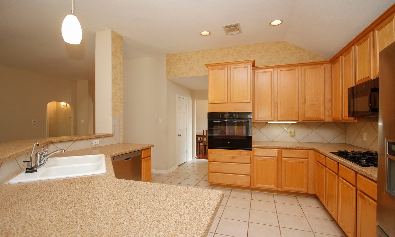 1114 Bringewood Chase Drive Spring, TX 77379 - Photo 17 of 49 a kitchen with stainless steel appliances granite countertop a sink and cabinets