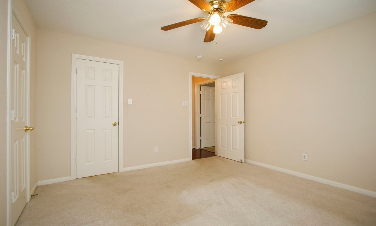 1114 Bringewood Chase Drive Spring, TX 77379 - Photo 32 of 49 an empty room with a chandelier fan and a ceiling fan