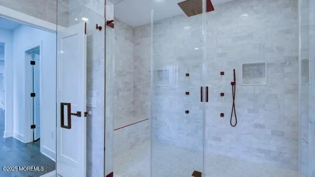 a bathroom with a sink a toilet a mirror and shower
