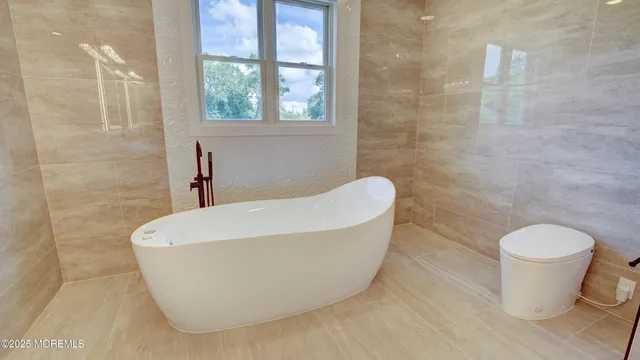 a view of a white house with large windows and a yard