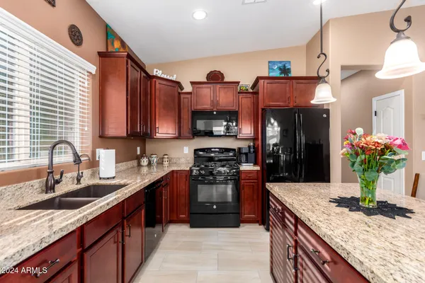 a kitchen with stainless steel appliances granite countertop a sink stove and refrigerator