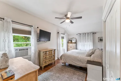 a bedroom with a bed a flat screen tv and a window