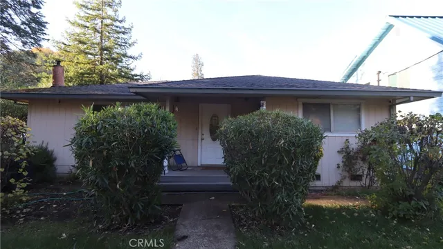 a view of a house with plants and a bench