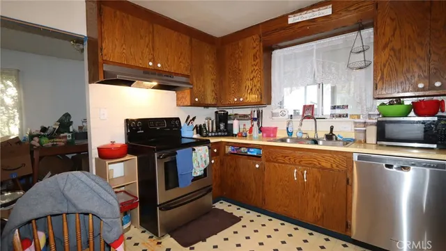 a kitchen with stainless steel appliances a stove a sink and a cabinets