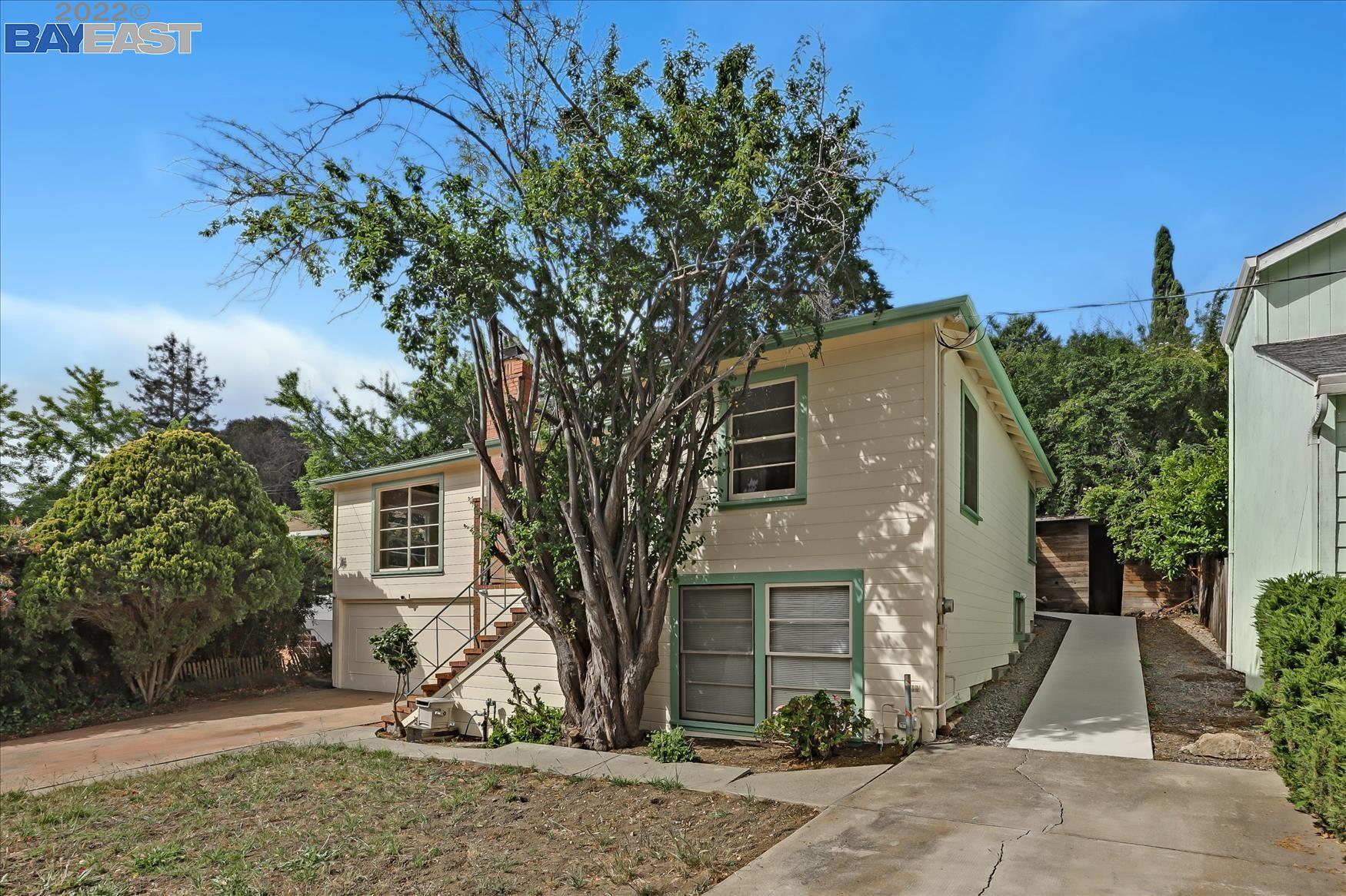 a front view of a house with a tree