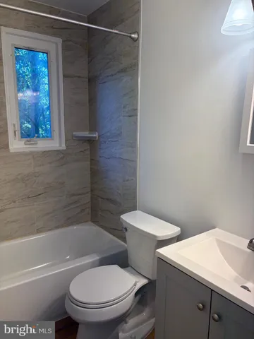 a white toilet and tub next to a bathroom
