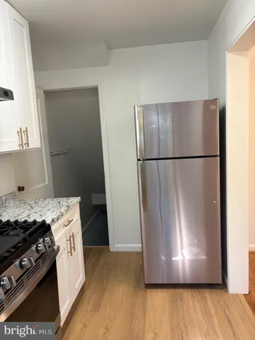 a view of a kitchen with a stove fridge and wooden floor