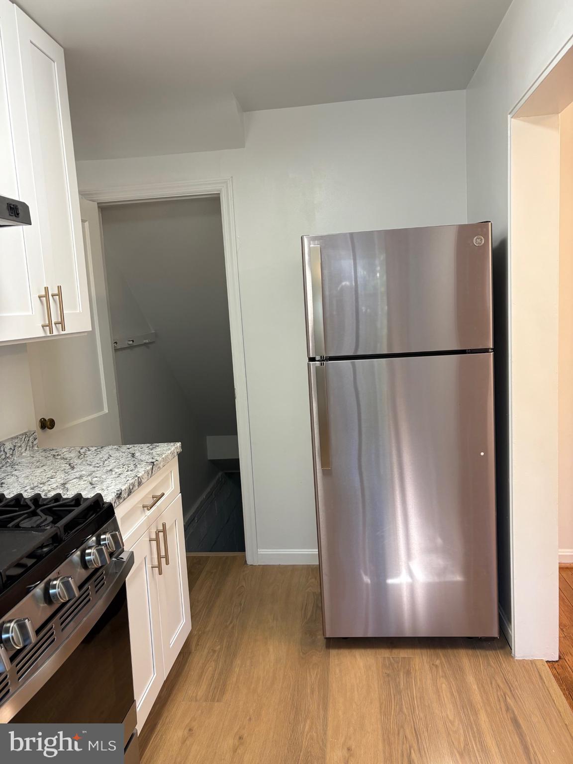 3222 13th Road South Arlington, VA 22204 - Photo 6 of 18 a view of a kitchen with a stove fridge and wooden floor