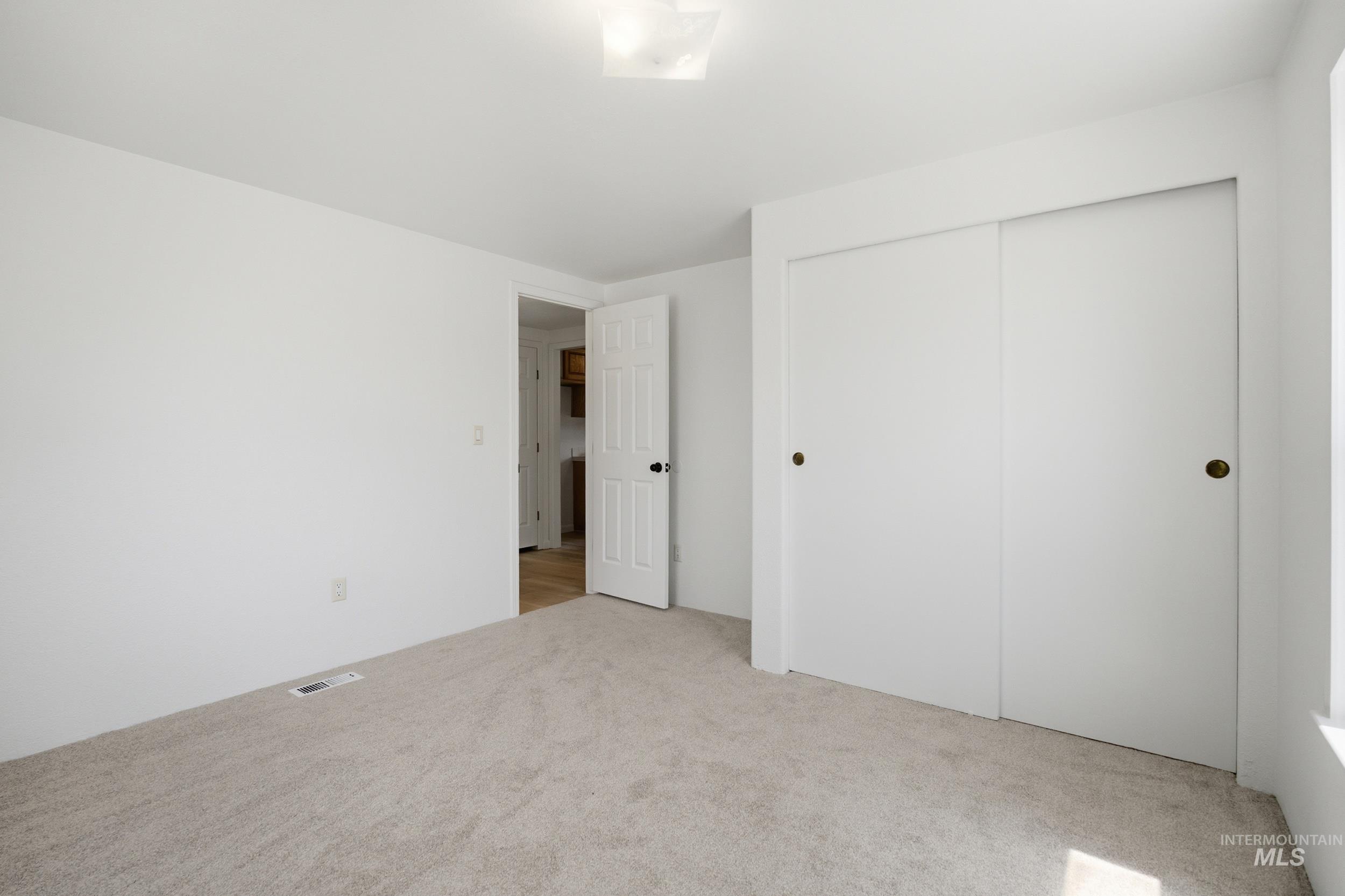 7422 Track Road Nampa, ID 83686 - Photo 27 of 50 Bathroom featuring a white toilet, light wood-finish flooring, a standing shower with chrome fixtures, and a tall wood-paneled storage cabinet