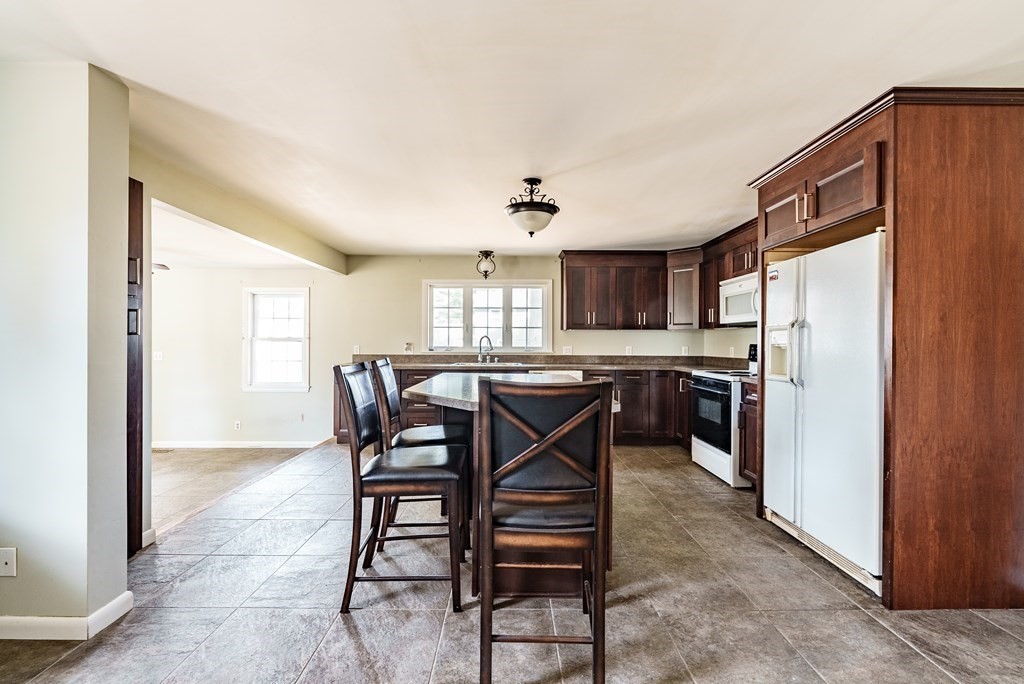 16 Middlebrook Drive Springfield, MA 01129 - Photo 8 of 30 a kitchen with stainless steel appliances kitchen island granite countertop a refrigerator a stove a microwave oven a sink with island and chairs in it