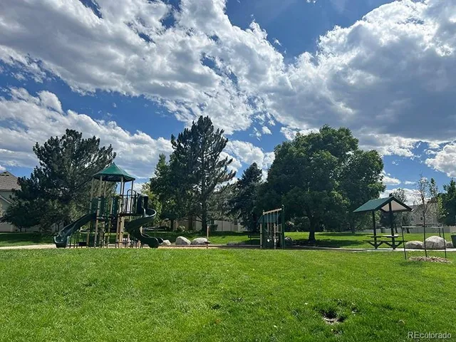 a view of a fountain in front of a house with big yard
